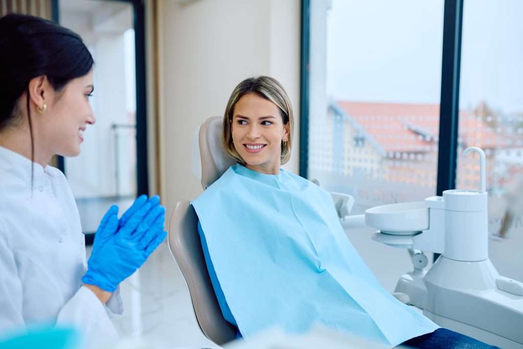 Dentist,In,Blue,Gloves,Talking,To,A,Happy,Woman,Patient