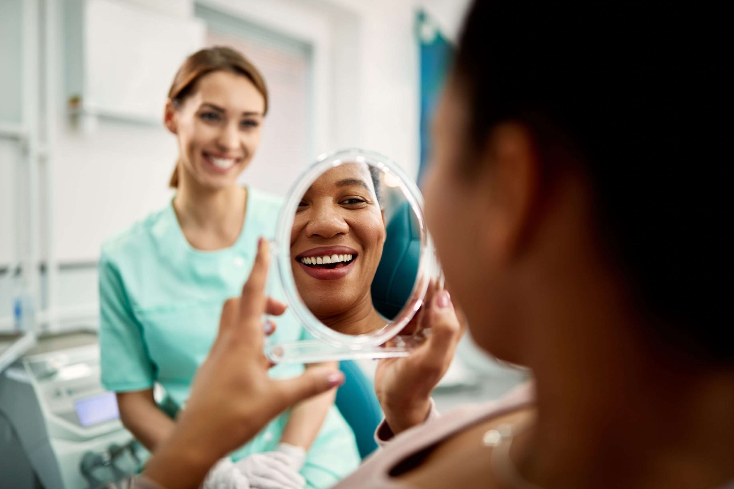 patient smiling into mirror